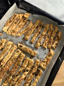 crackers maison aux graines sur une feuille de papier sulfurisé